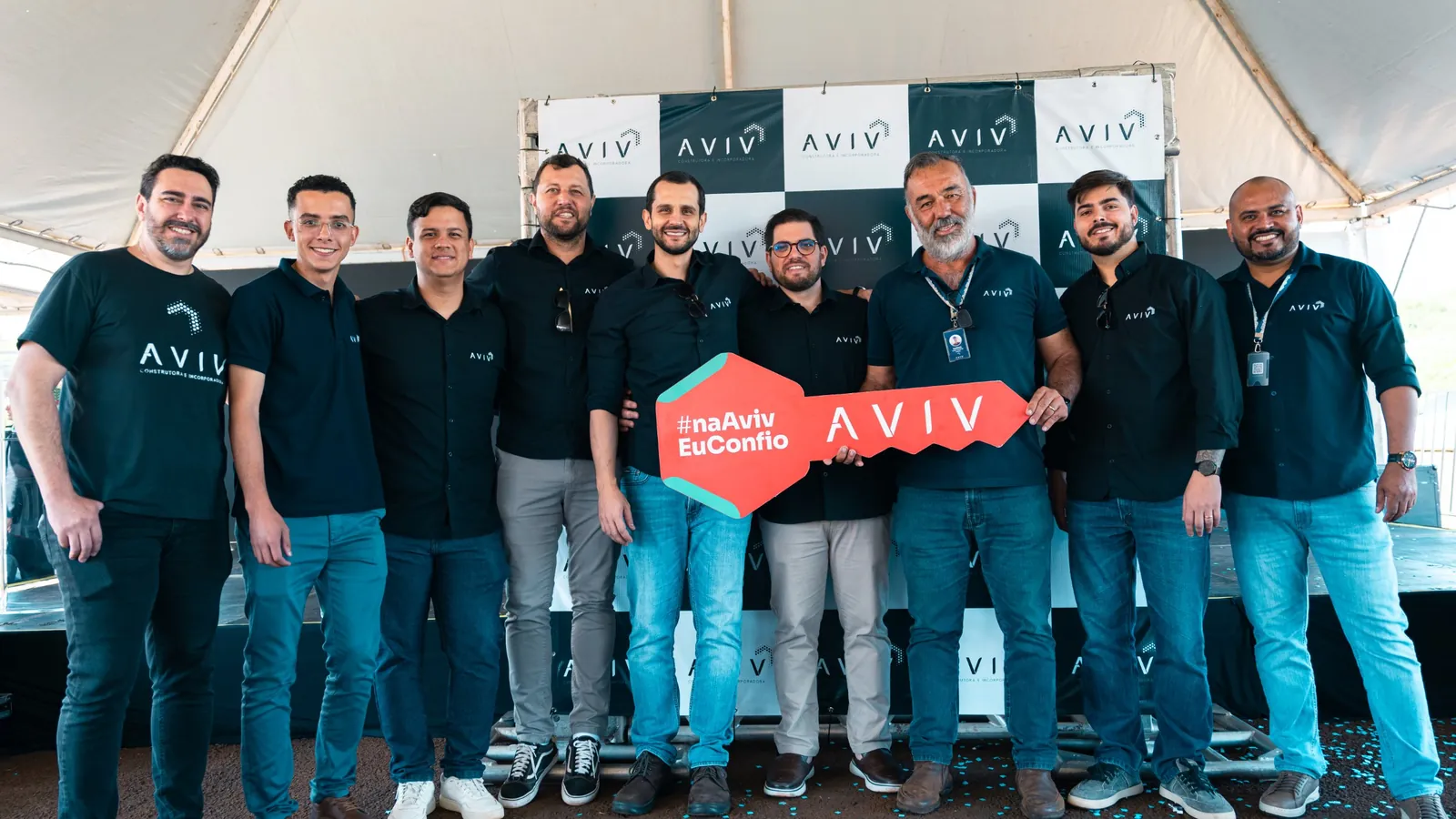 Equipe da AVIV posando com a chave gigante da campanha #naAvivEuConfio